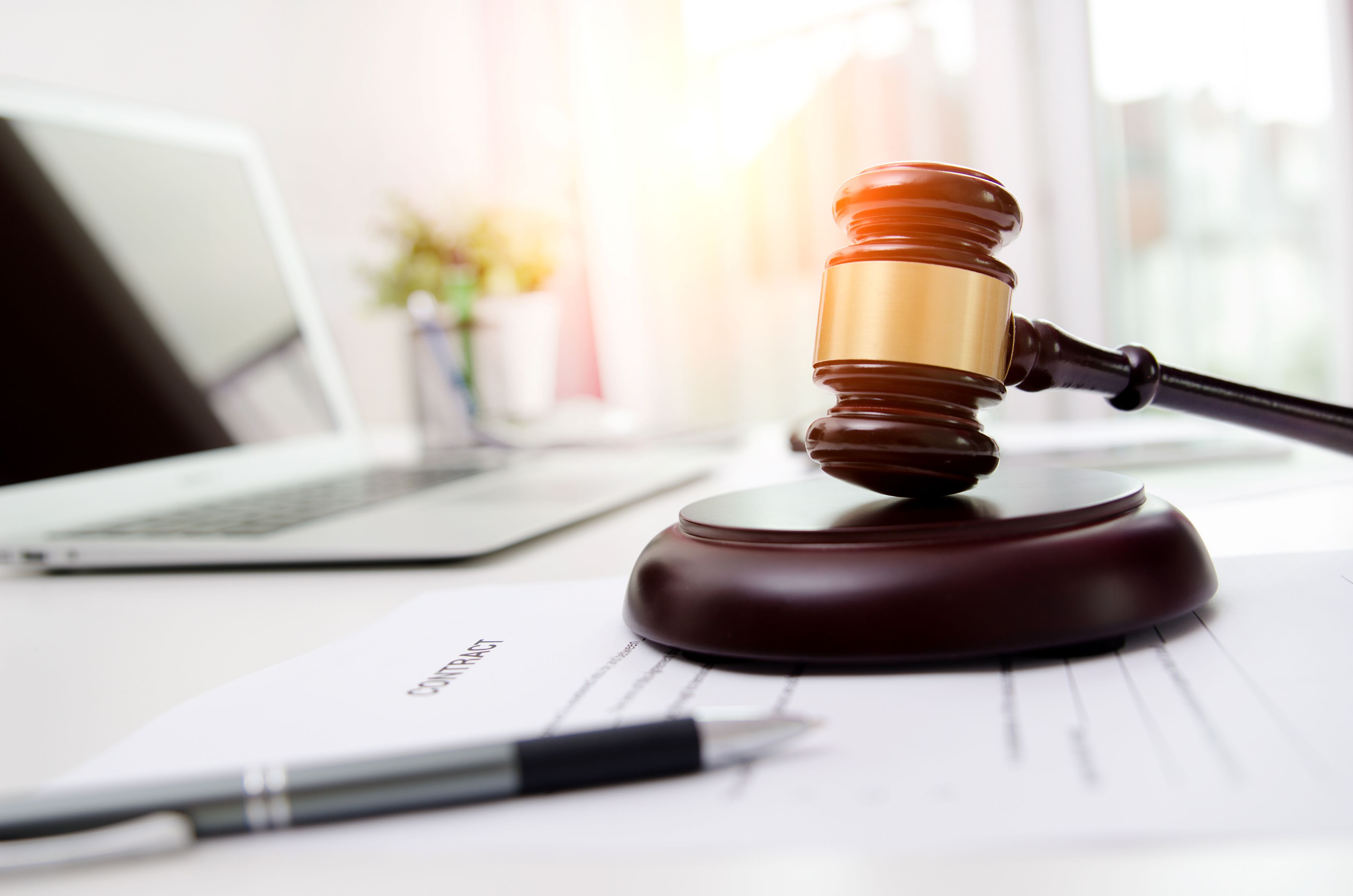 Auction gavel with laptop in background online auction istock 974329568