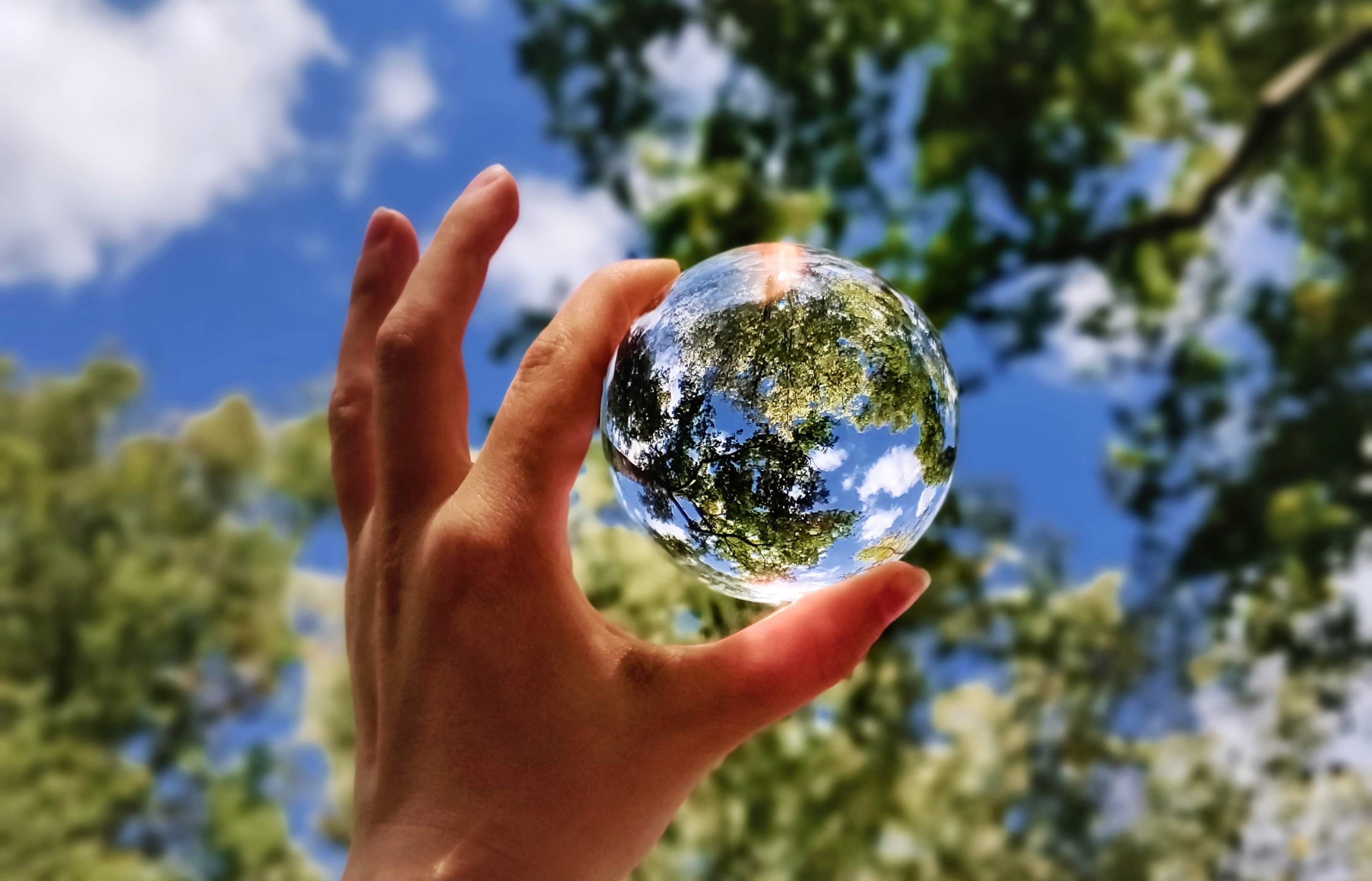 Hand holding glass sphere